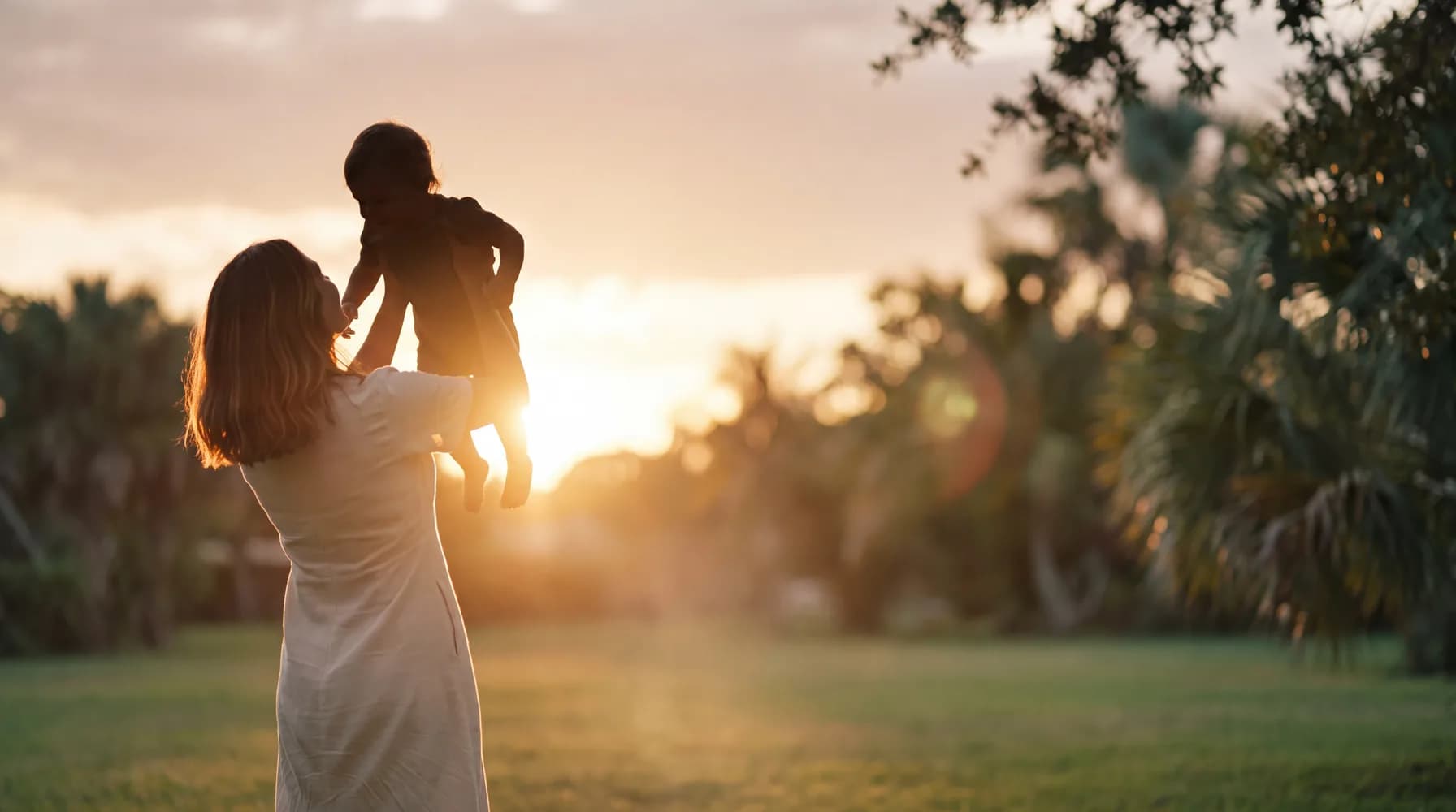 Una mamá y su niño en un jardín con luz natural